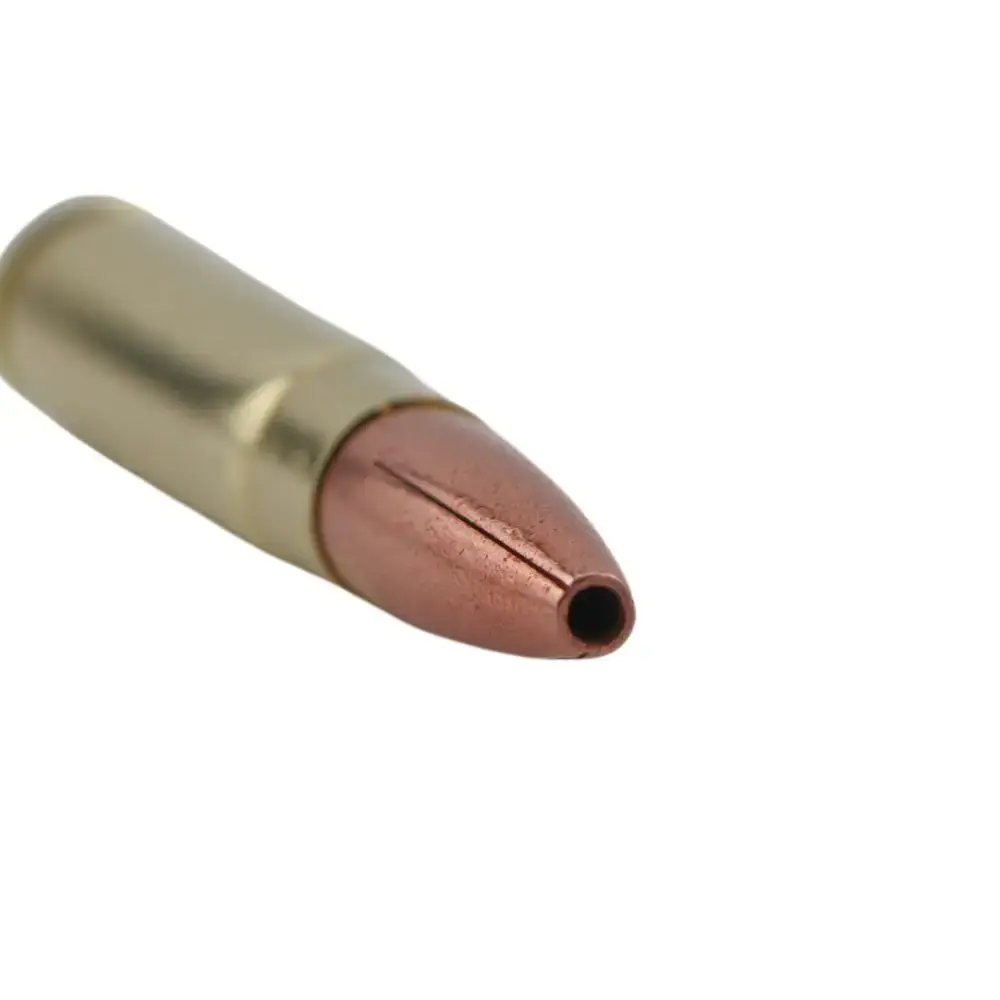 Close-up of a copper-jacketed bullet with a brass casing pointing to the right.
