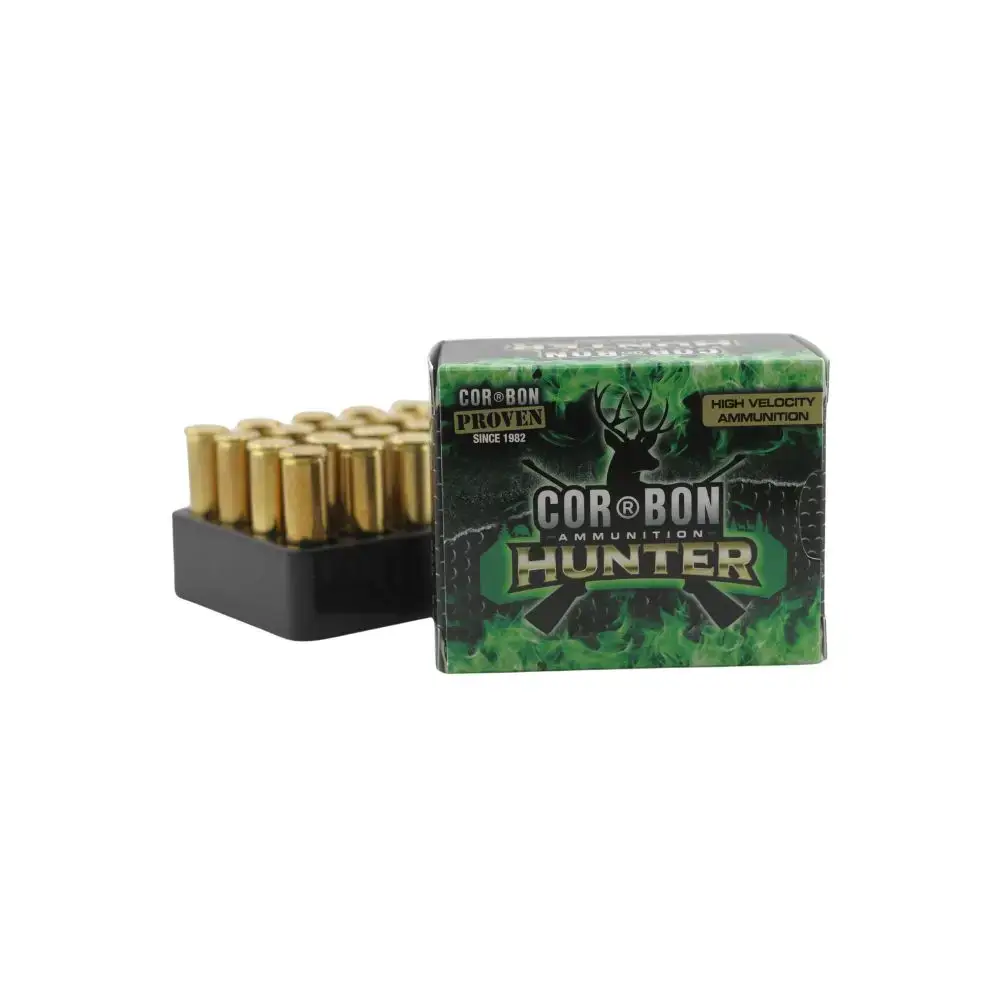 Box of Cor-Bon Hunter ammunition with brass cartridges in a black tray beside it.